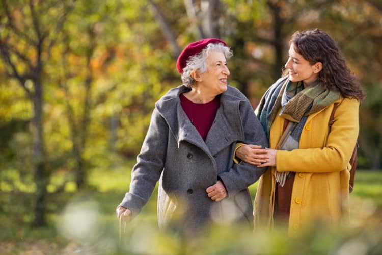 banner in column autumn grandmother granddaughter walking arm in arm