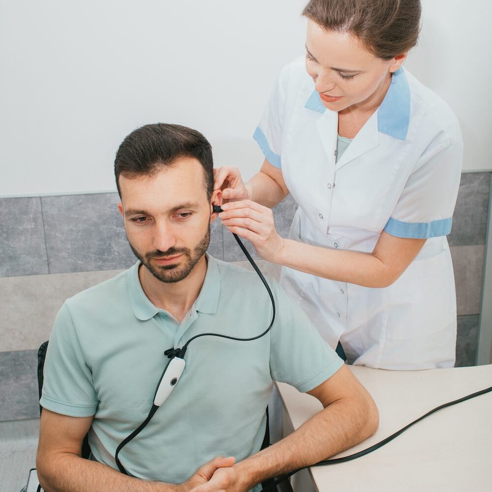 audiologist testing patient's hearing ability