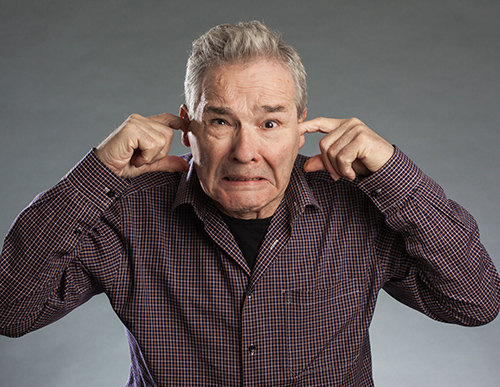 Man Holding his Ears | People Who Deny Hearing Loss