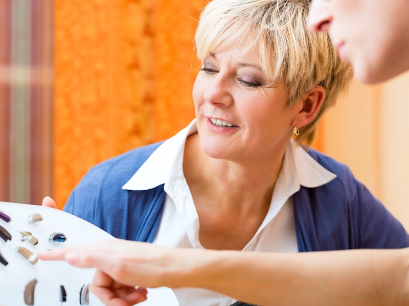 Woman suffering from hearing loss choosing a hearing aid.
