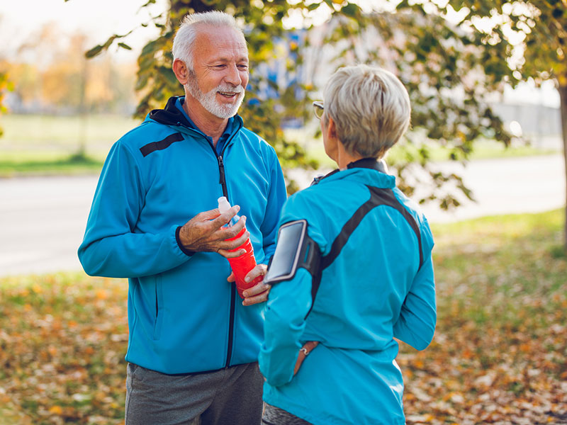 Woman with hearing aid outrunning her husband on the track.