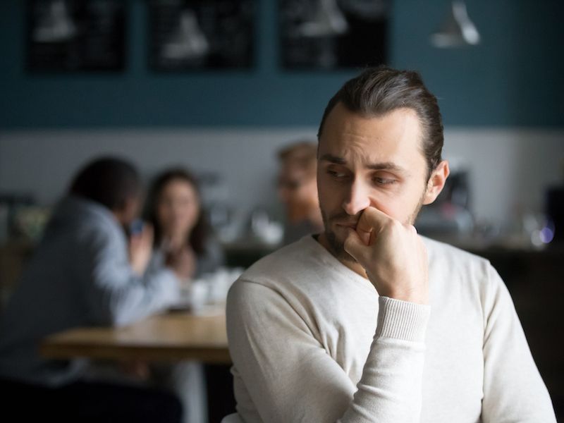 Man isolated and depressed in a cafe because he has hearing loss.