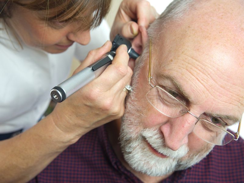 Man getting a hearing test and annual hearing check up to make sure his hearing aids work.