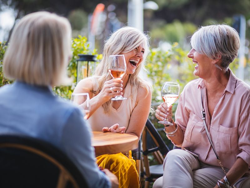 Group of women practicing using their new hearing aids during lunch.