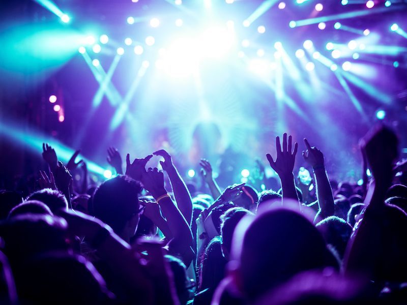 Musician on stage performing with hearing protection to protect against tinnitus and hearing loss.
