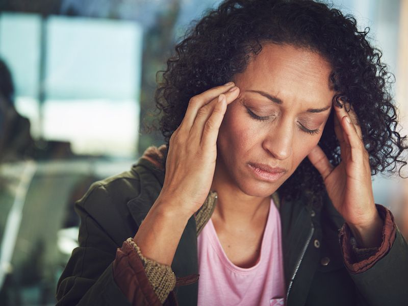 Woman with hands to her ears in pain wondering when the ringing in her ears will stop.