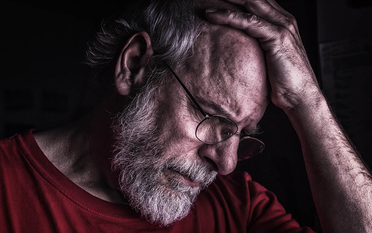 Man having trouble remembering things because of brain strain related to hearing loss.