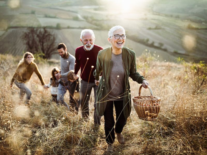 Woman wearing hearing aids climbing hill with family and laughing at a joke.