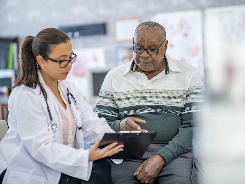 Man talking with healthcare provider about his diabetes and hearing loss.