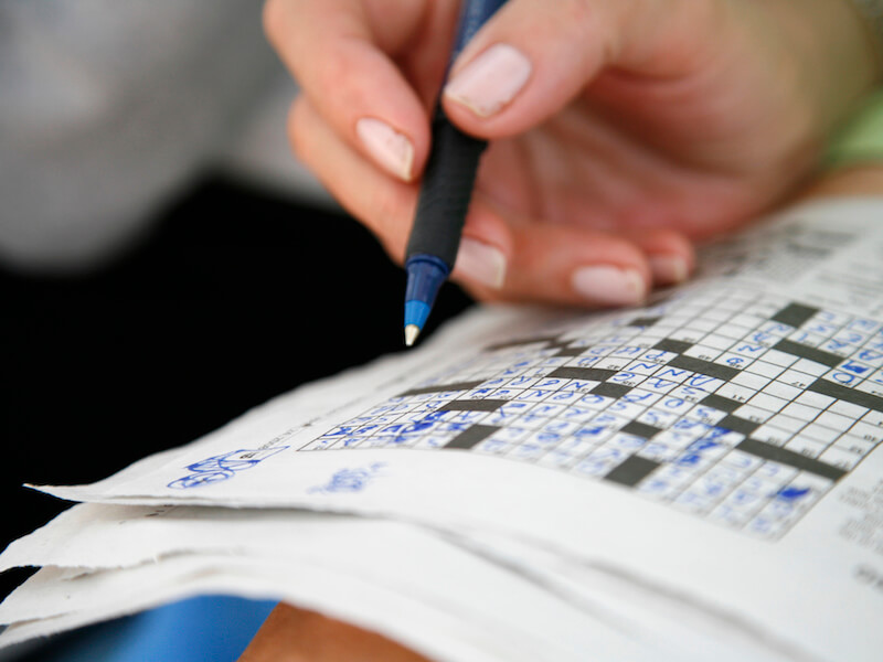 Woman struggling with a crossword puzzle because she has hearing loss induced memory loss.