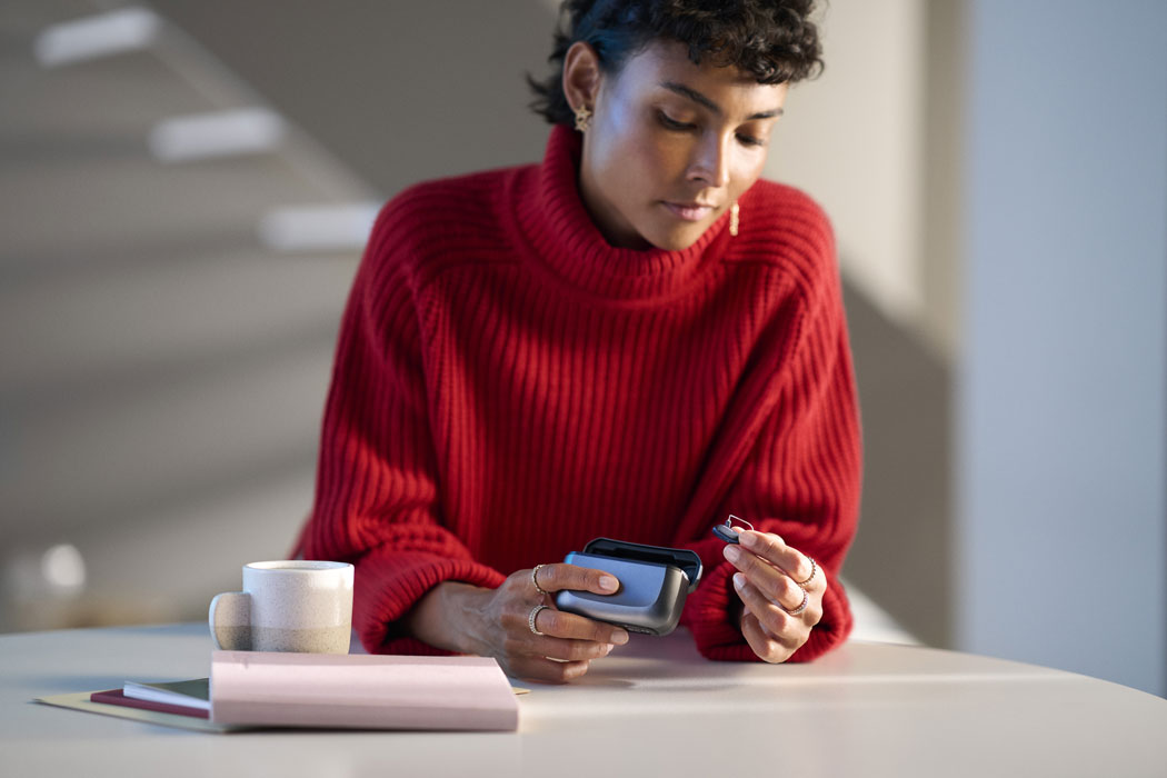 ReSound Vivia lifestyle woman taking hearing aids out of charging case