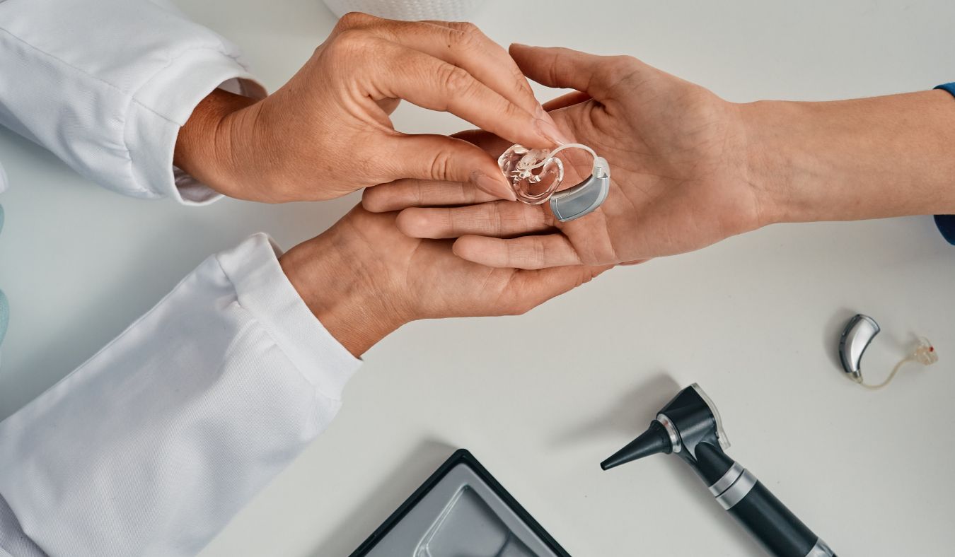 hearing solutions audiologist his showing hearing aid to patient