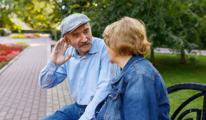 event image hand to ear senior man and woman outside
