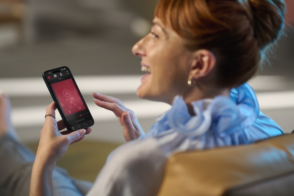 A person streaming audio to their hearing aids from a smartphone