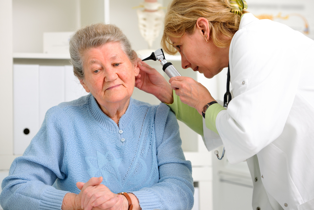 audiologist inspecting inner ear canal of patient