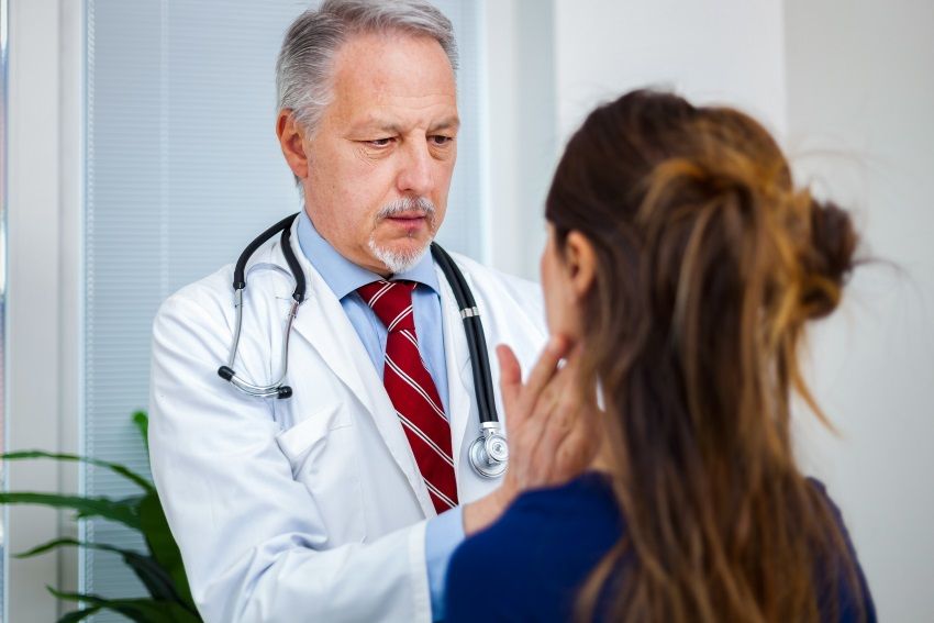 an ent doctor inspecting a patient for swollen lymph nodes