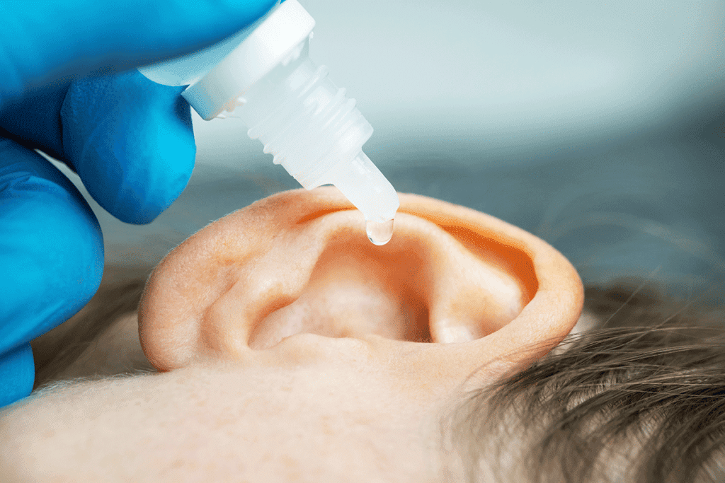 doctor dripping solution into patient's ear