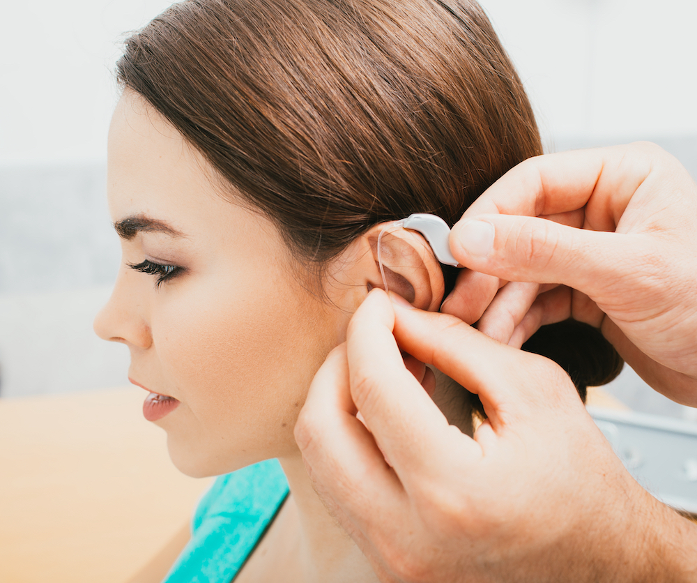 woman looking forward while being fitted with new hearing aids