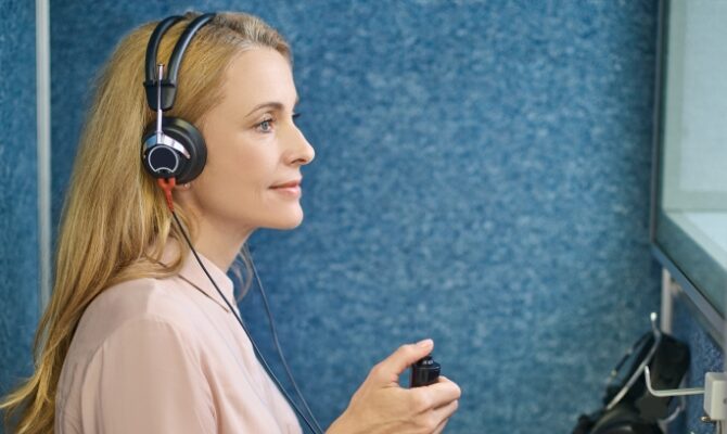 cta stacked woman taking hearing test in sound booth