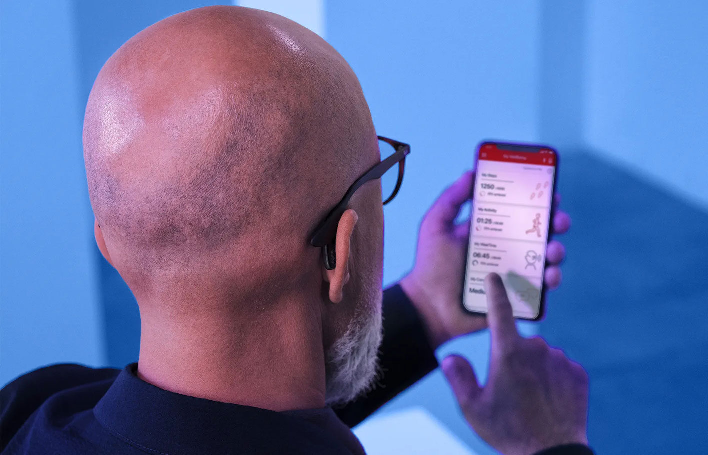 SIGNIA man wearing hearing aids using phone app to connect
