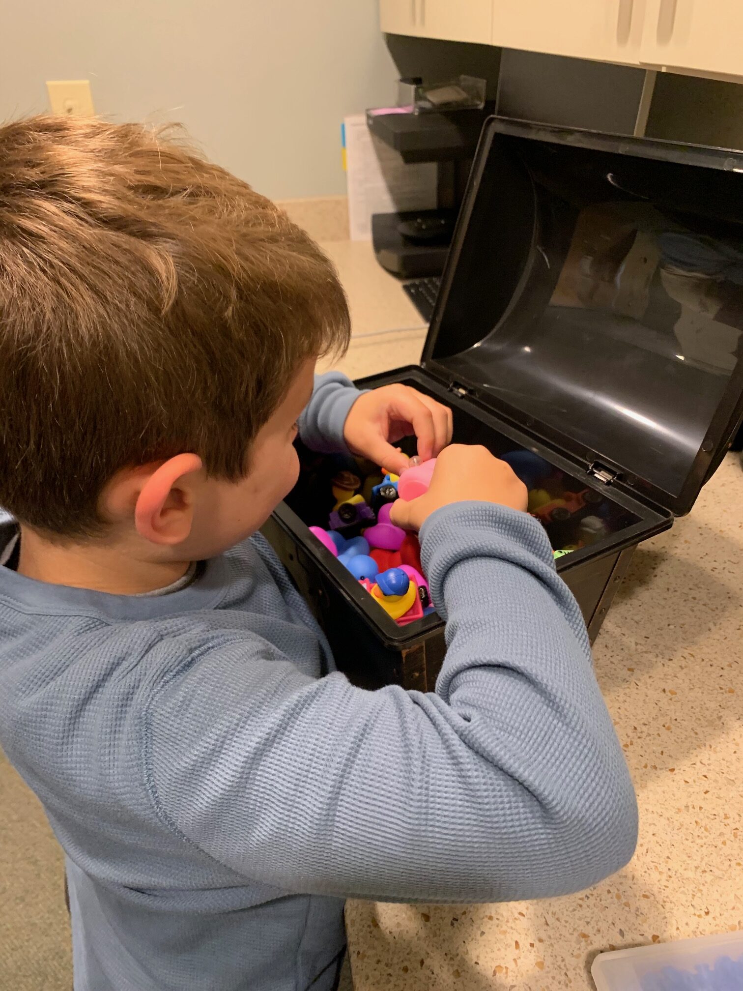 child picking toy from prize chest