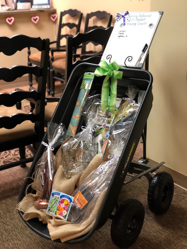 a gift basket sitting in a room with wooden chairs
