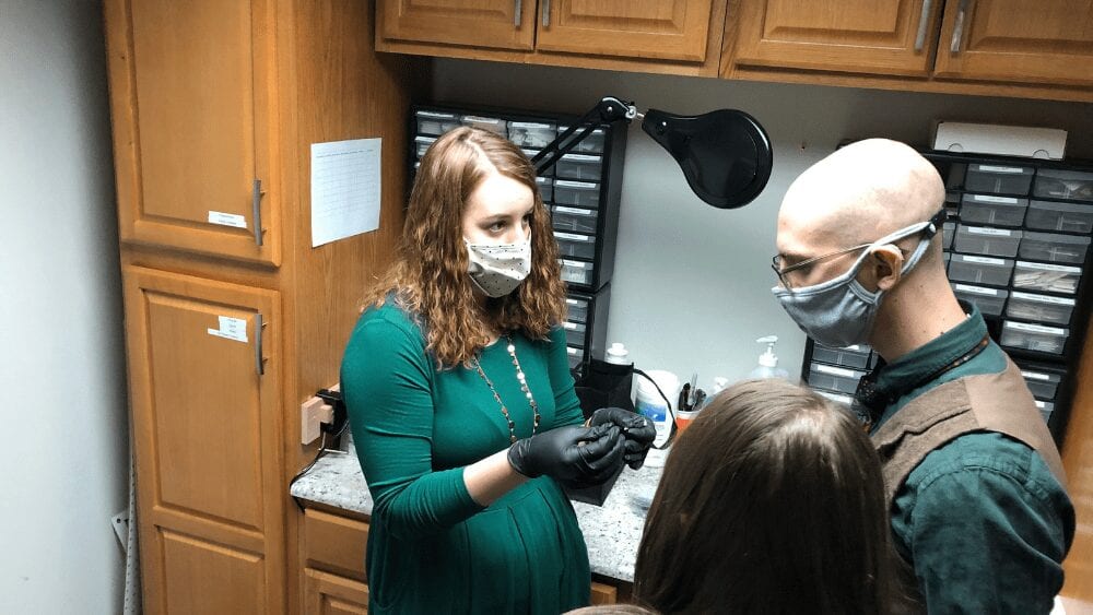 a hearing instrument specialist showing her patient new hearing aids