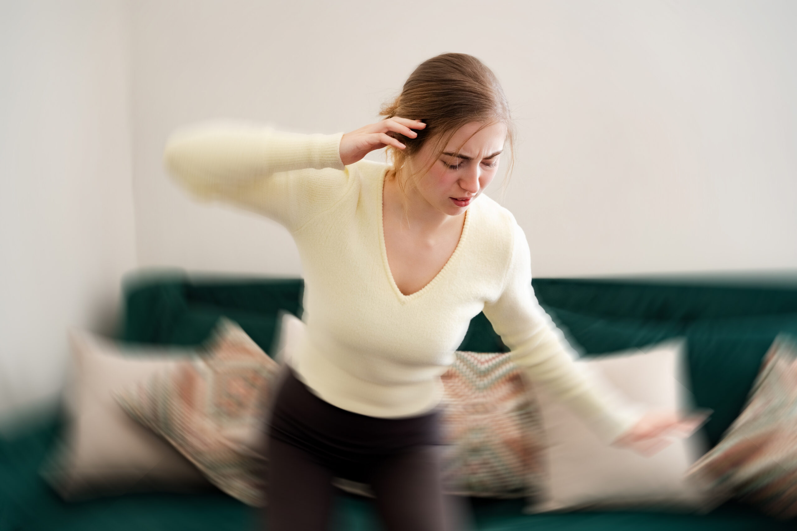 Young woman gets dizzy, loses her balance in the living room Tired girl with closed eyes having dizziness holding hand on head at home Vertigo disorder low blood pressure vestibular health problems