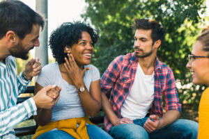 Woman with ear hearing problem having fun with her friends in th