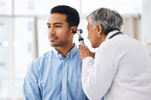 Doctor check patient ear, consultation and healthcare, people at hospital with otolaryngology specialist Man and senior physician woman with otoscope test for hearing problem and health insurance
