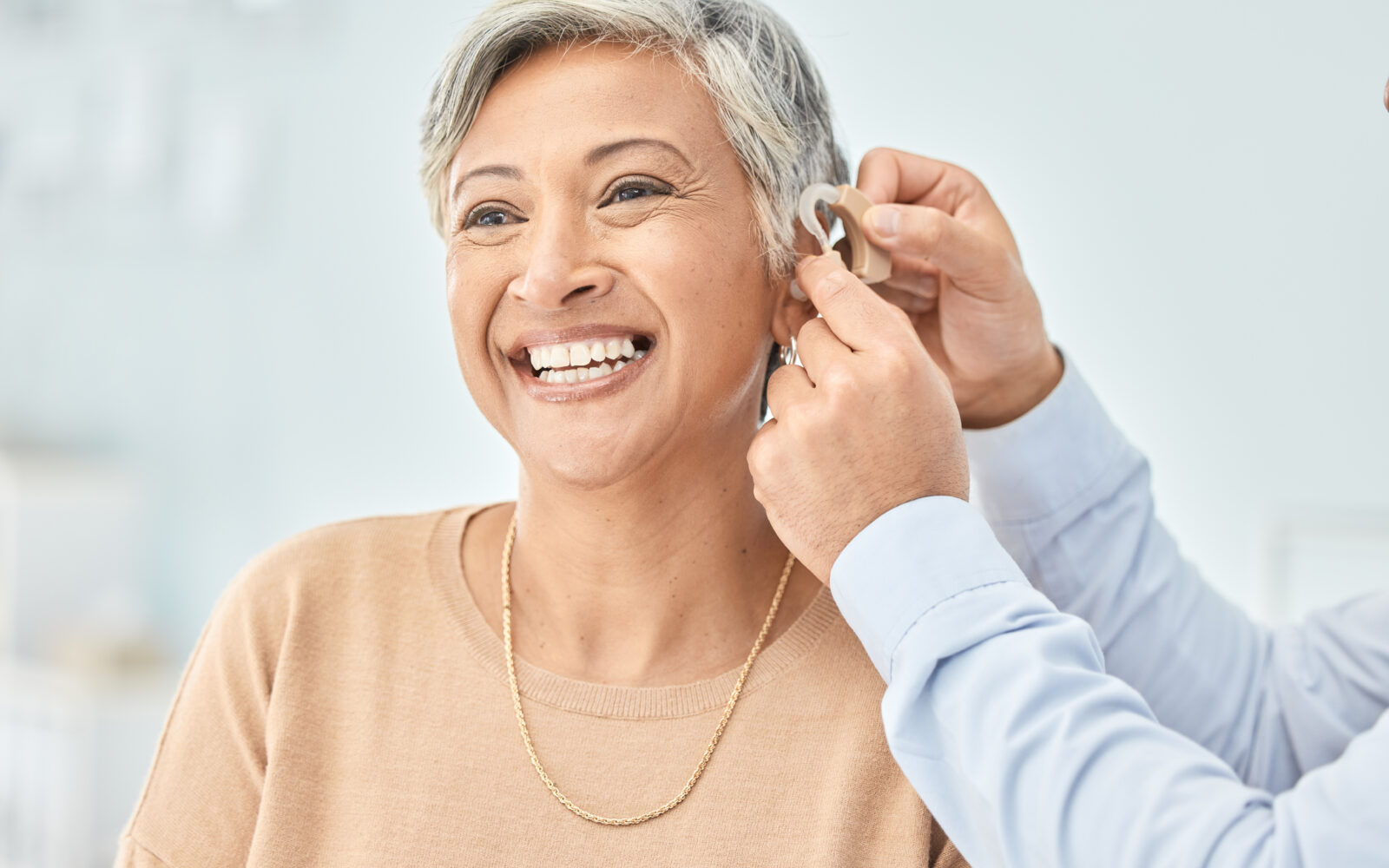 Senior patient, hearing aid and doctor hands, ear and listening, help and trust, healthcare and medicine Medical tech, consultation with ENT specialist and health, happy woman and people at clinic