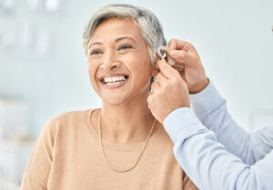 Senior patient, hearing aid and doctor hands, ear and listening, help and trust, healthcare and medicine Medical tech, consultation with ENT specialist and health, happy woman and people at clinic