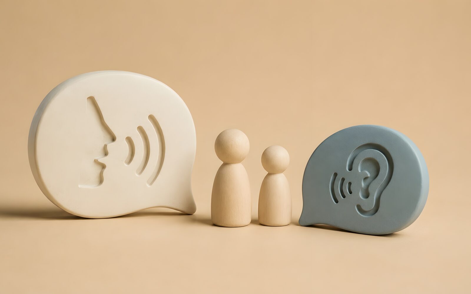Wooden figures representing a family or team engaging in active listening and open communication for child psychology therapy or peaceful dispute resolution