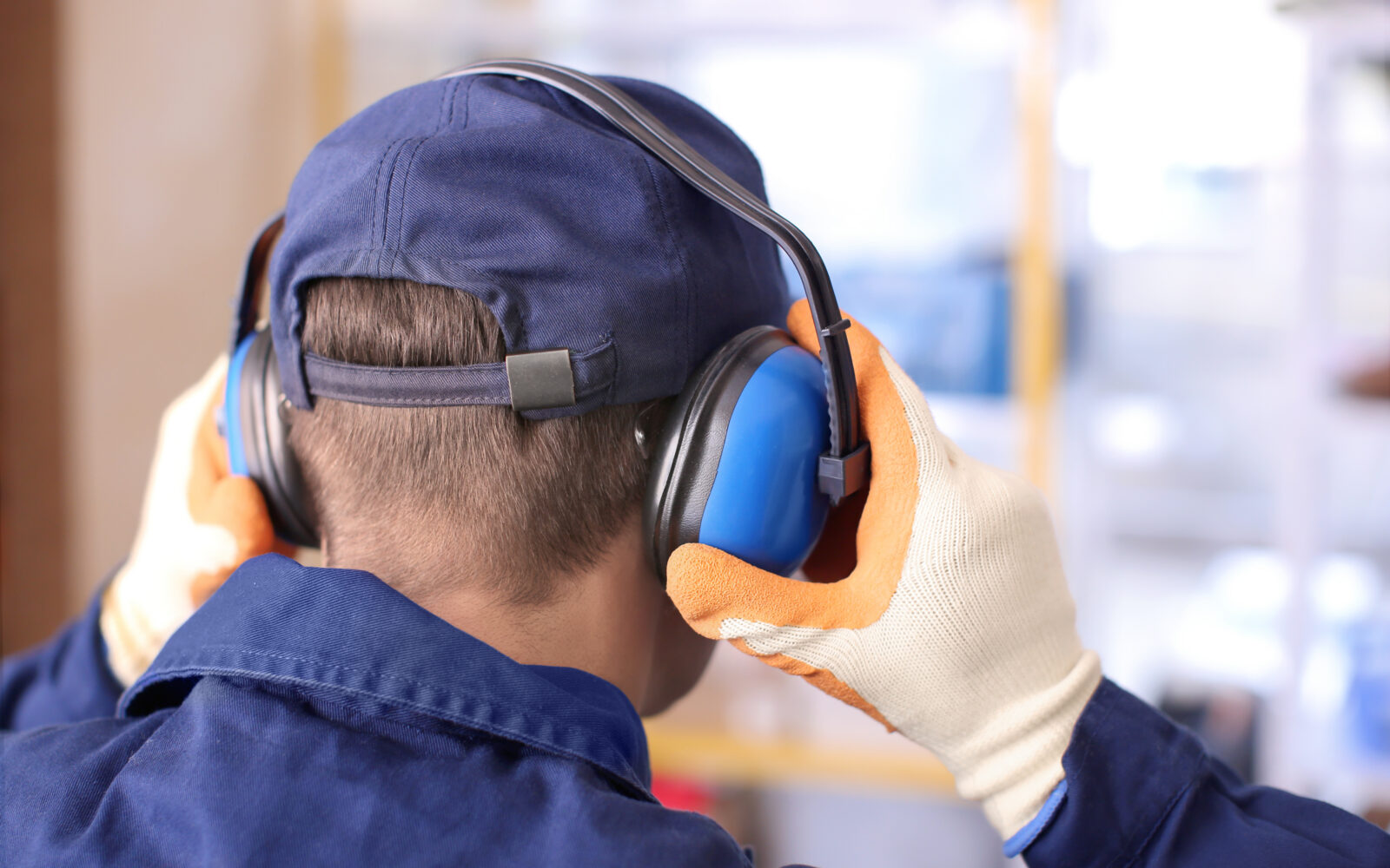 Male worker with hearing protectors, indoors