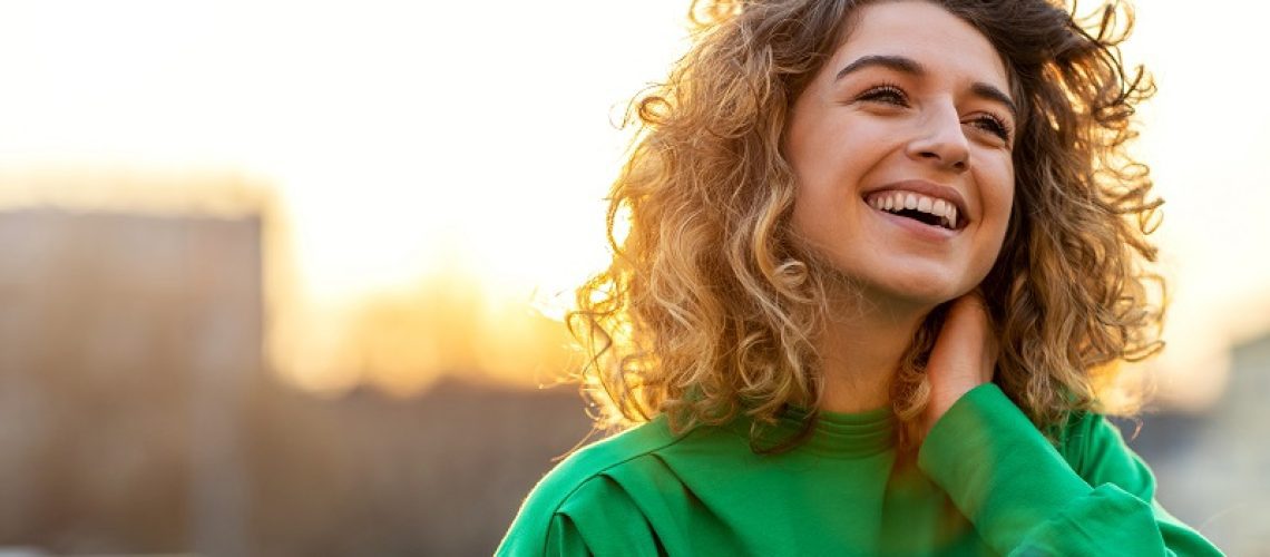 woman smiling with sunset in the background