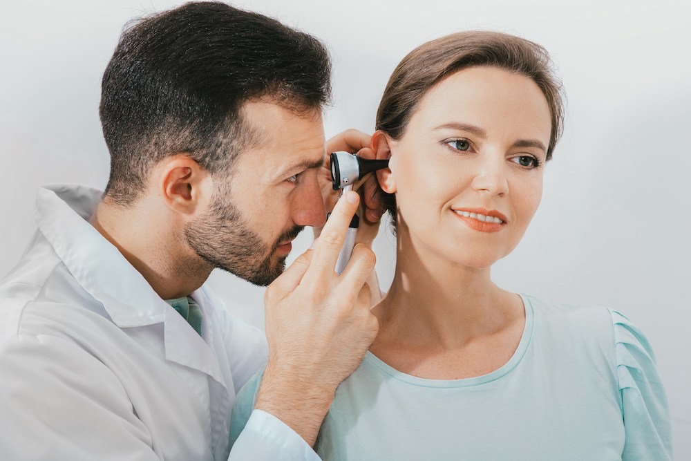 smiling hearing loss patient sitting for diagnostic evaluation