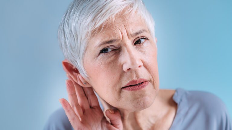woman holding hand to ear
