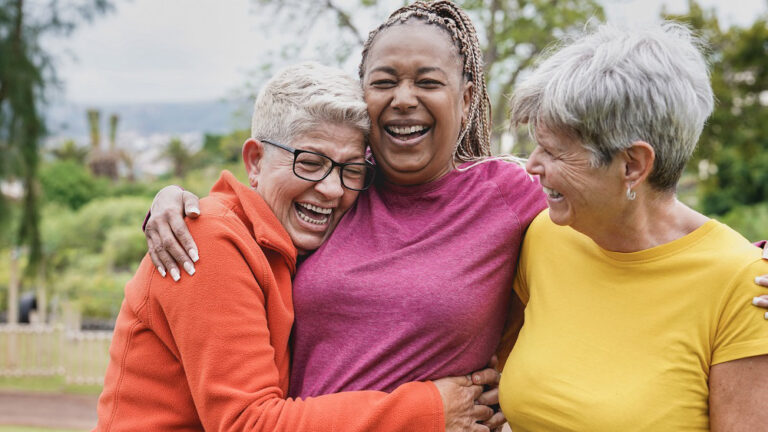 three woman with hearing loss wearing colorful shirts