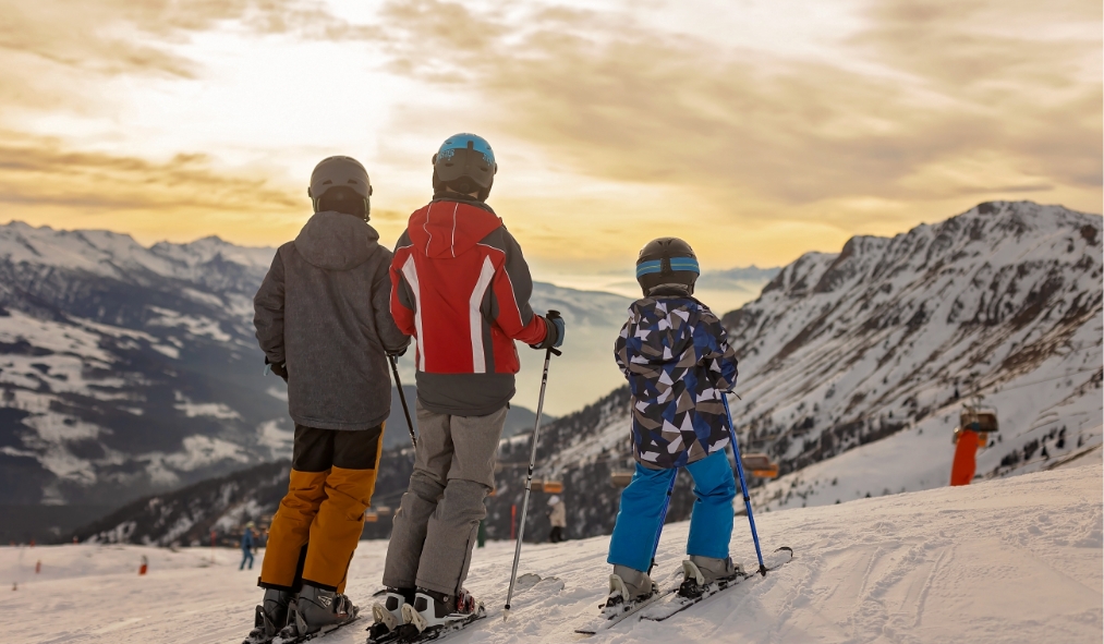 events skiing family admiring sunset while skiing