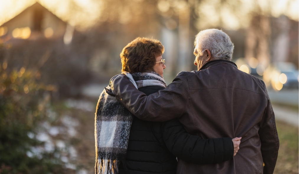 events winter senior couple hugging outside backs facing view