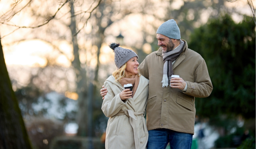 events winter couple holding coffee hot chocolate walking outside