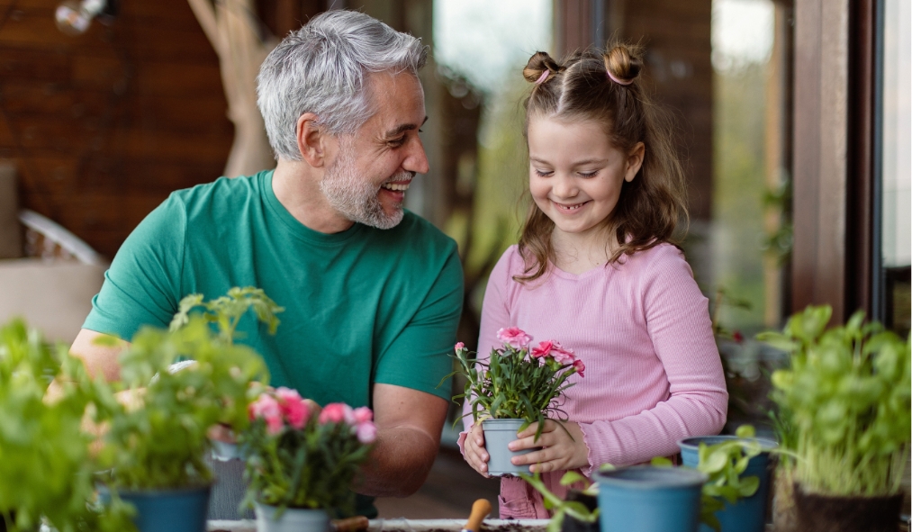 spring father planting flowers with daughter
