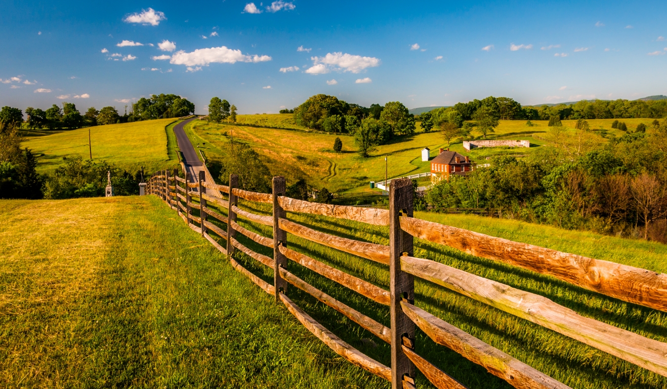 Fence and view of rolling hills and farmland