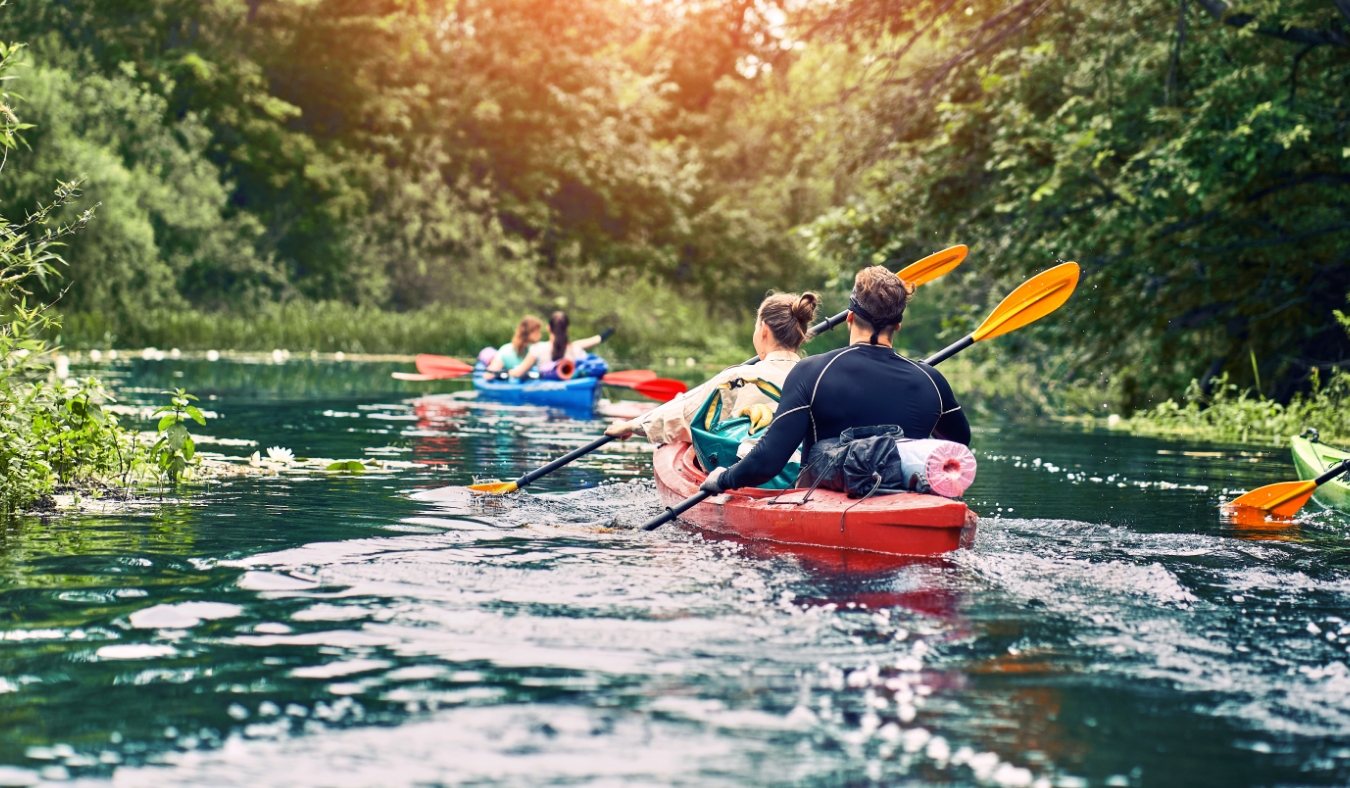 group of young people on kayak outing rafting down the river