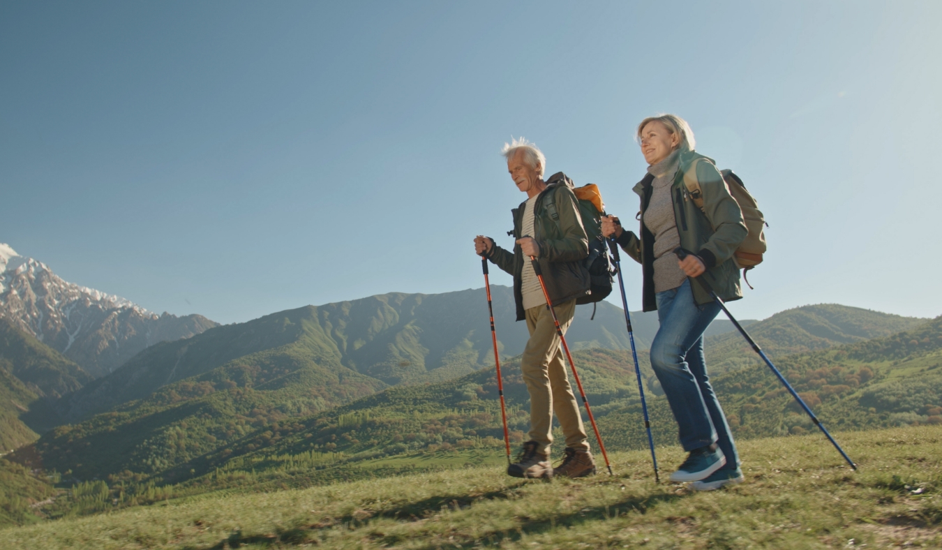 Mature caucasian couple on vacation having a hike in spring mountains spending time together