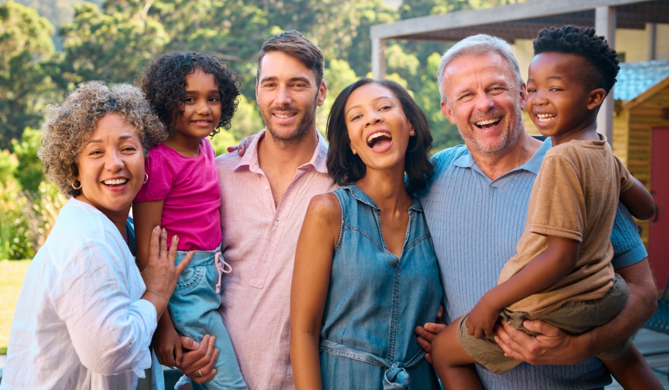 Portrait Of Three Generation Multi Racial Family Laughing And Smiling Outdoors In Countryside