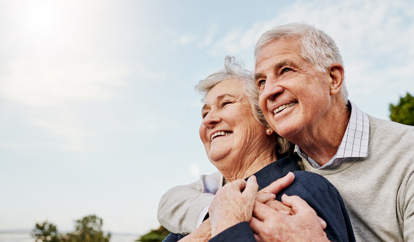 senior couple admiring view in nature hugging