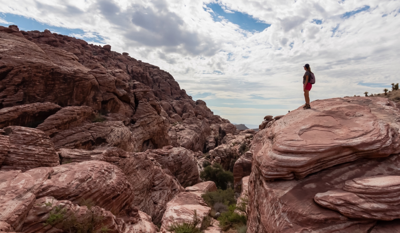 Woman standing on edge of rock formation with scenic view of limestone rock