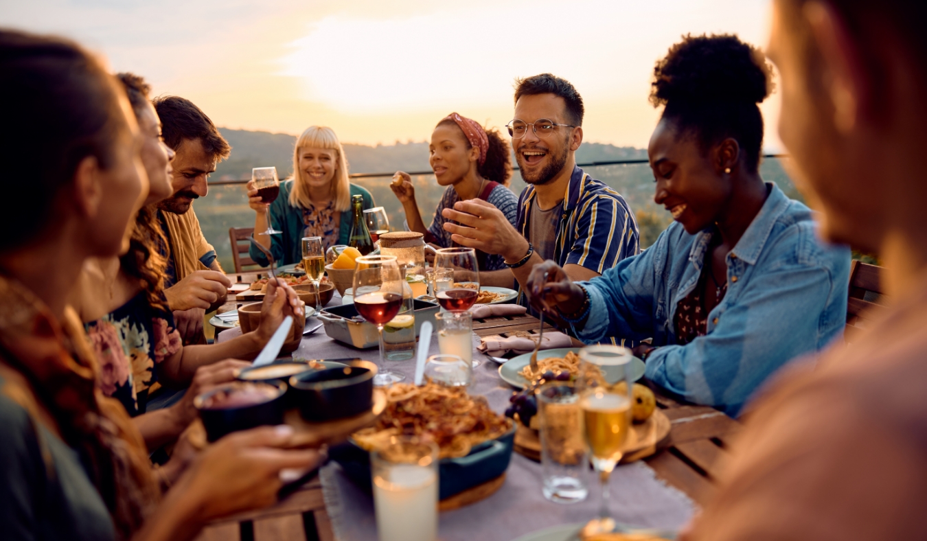 gathering for meal on a patio at sunset