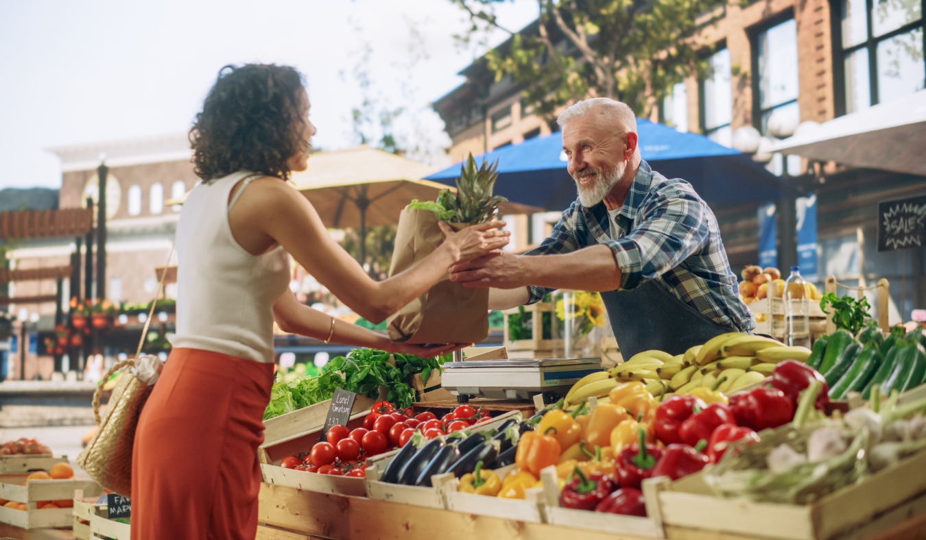 local farmer selling products at market stall